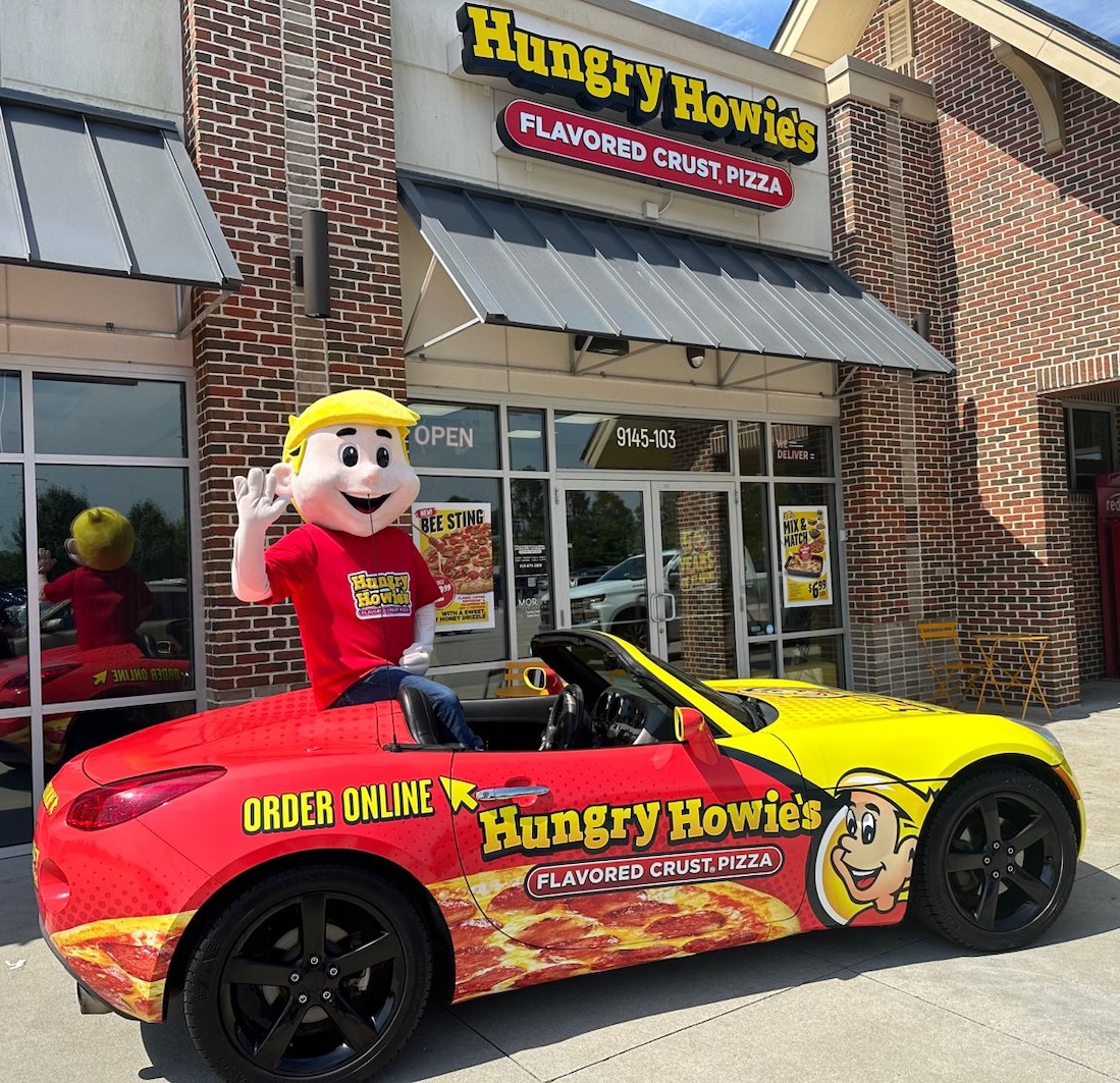 Hungry Howie's mascot in vehicle in front of Hungry Howie's restaurant