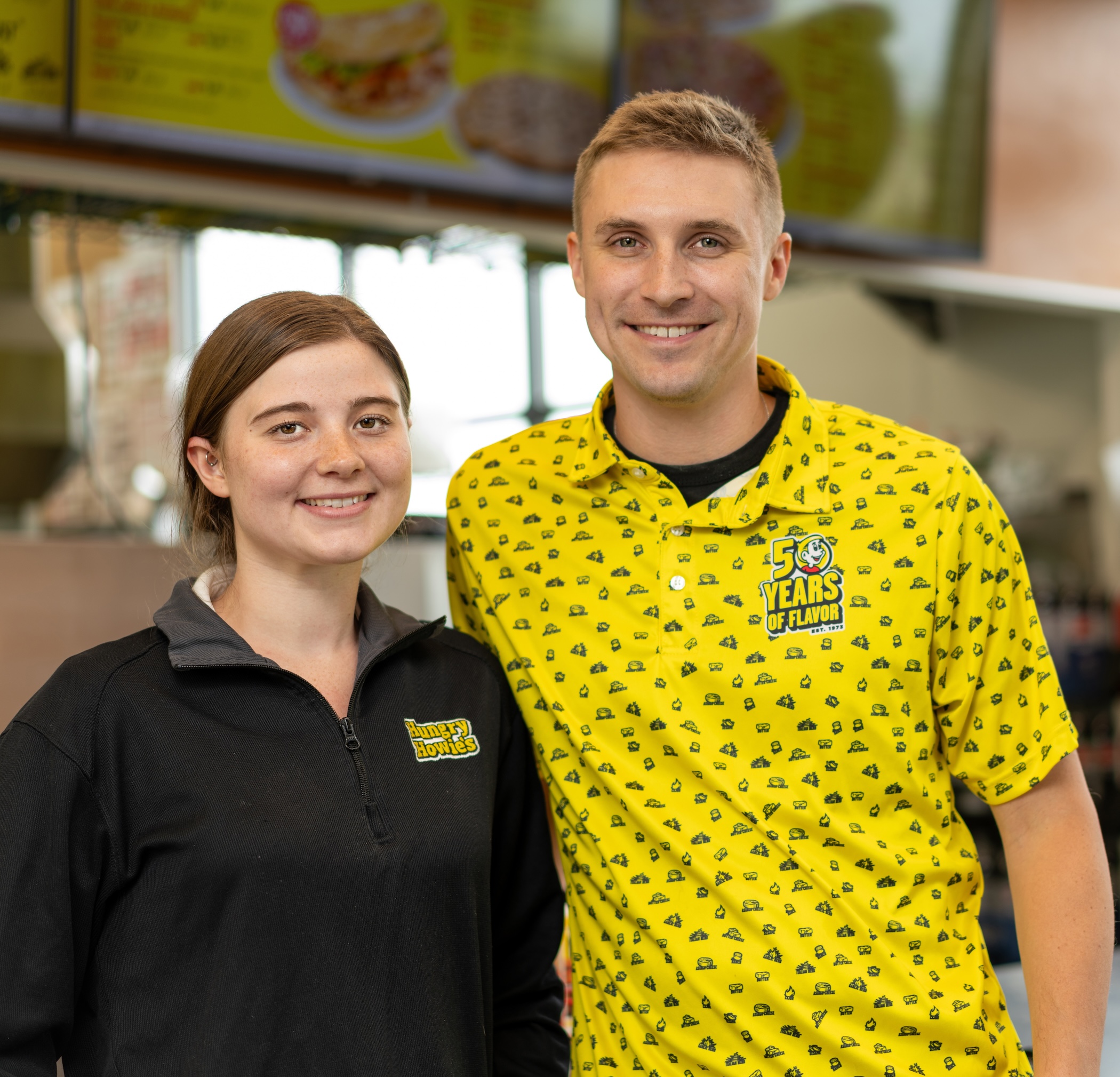 Two smiling Hungry Howie's franchise owners