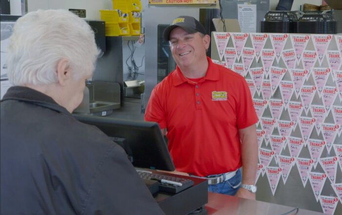 Franchise owner smiling at a customer