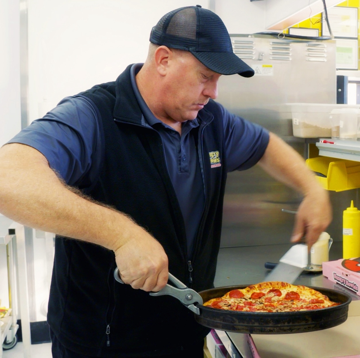 Hungry Howie's employee making a pizza