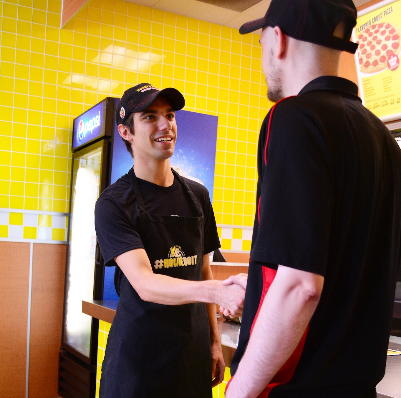 Two Hungry Howie's employees shaking hands