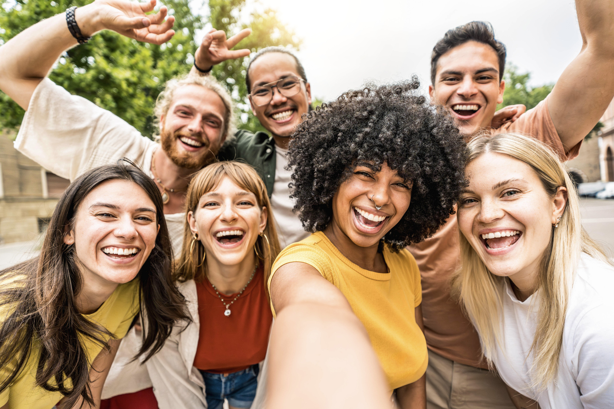 Multicultural friends smiling at camera together outside