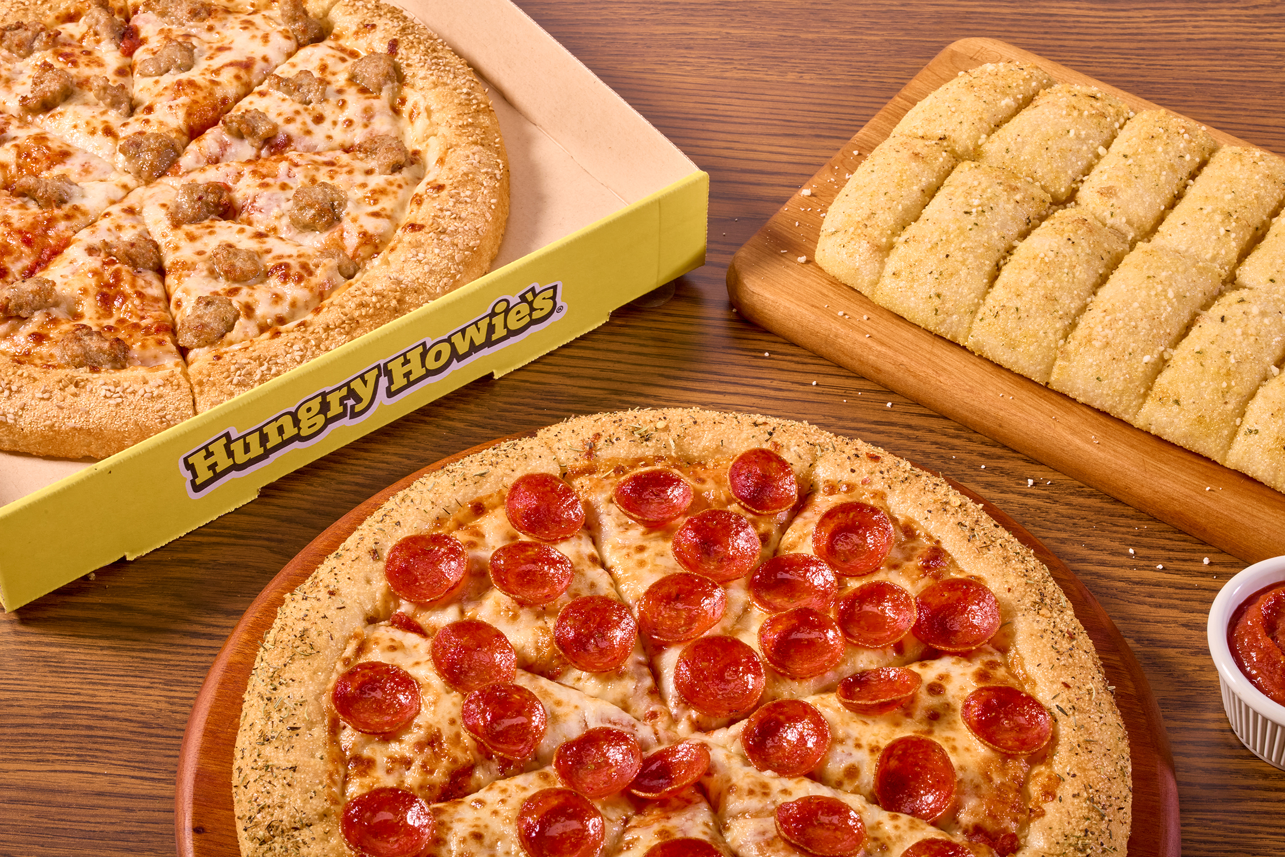 Overhead shot of a pepperoni pizza, sausage pizza and breadsticks Overhead shot of a pepperoni pizza, sausage pizza and breadsticks