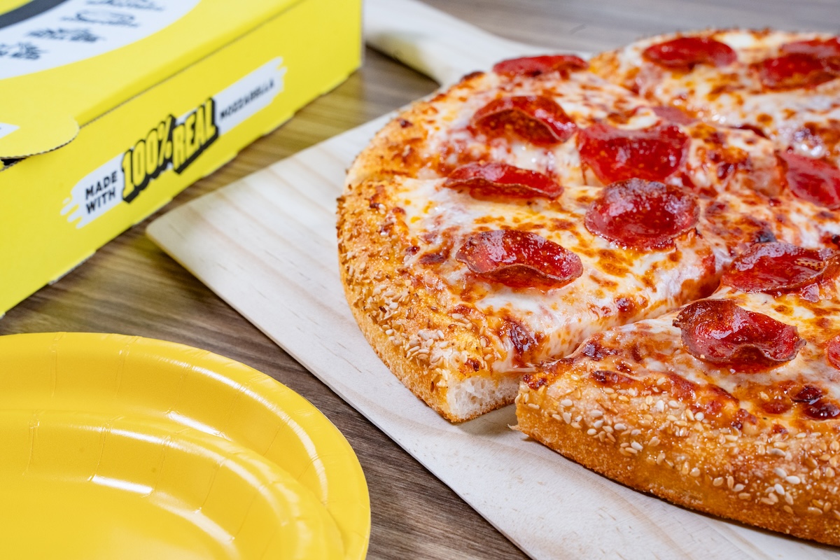 Photo of a large pepperoni pizza with a hungry howie’s pizza box in the background Photo of a large pepperoni pizza with a hungry howie's pizza box in the background