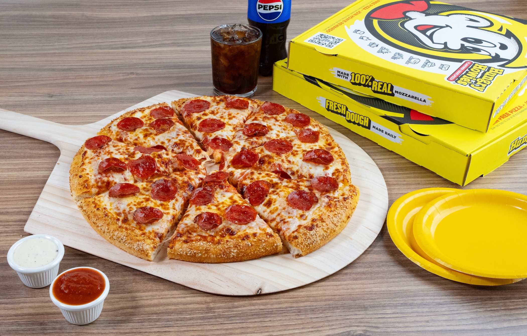 Pepperoni pizza, with two pizza boxes behind it and a pepsi soda bottle Pepperoni pizza, with two pizza boxes behind it and a pepsi soda bottle